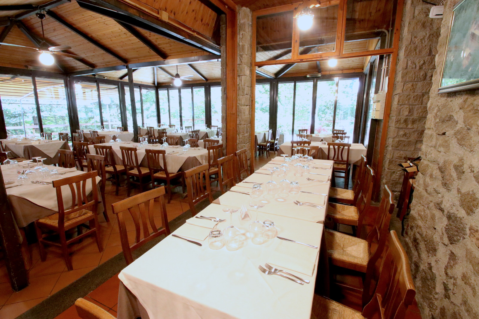 Ristorante con tavoli apparecchiati e ampie finestre panoramiche.