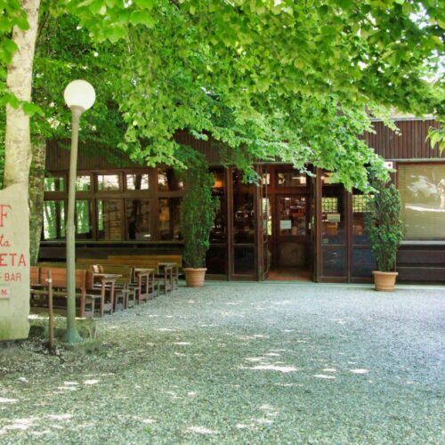 Ingresso del ristorante "La Faggeta" circondato da alberi.
