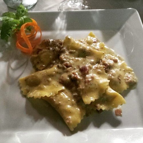 Ravioli con salsa cremosa e guarnizione di carota.