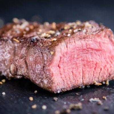 Bistecca al sangue con pepe su sfondo scuro.